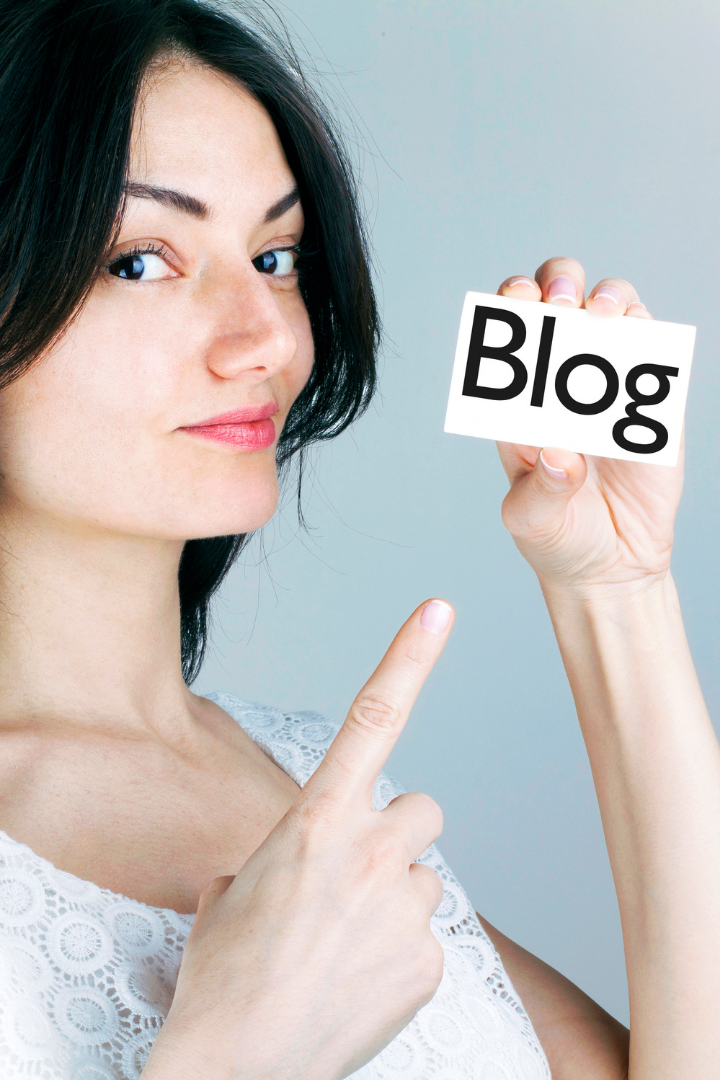 Woman pointing to card that reads "Blog"